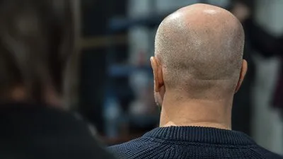 Back view of the man with a bald head in a conference hall.