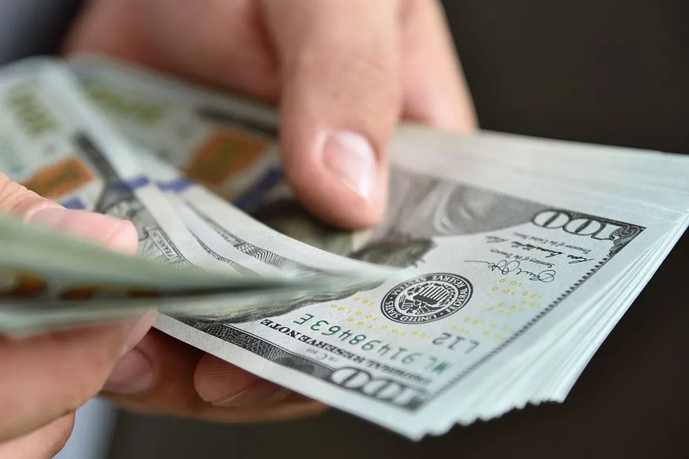 Close up of businessman counts money in hands.