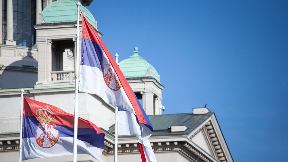 Serbian flags displayed in front of the Serbian Parliament building, symbolizing national pride and identity. Serbia is a nation of Balkans, in Europe.