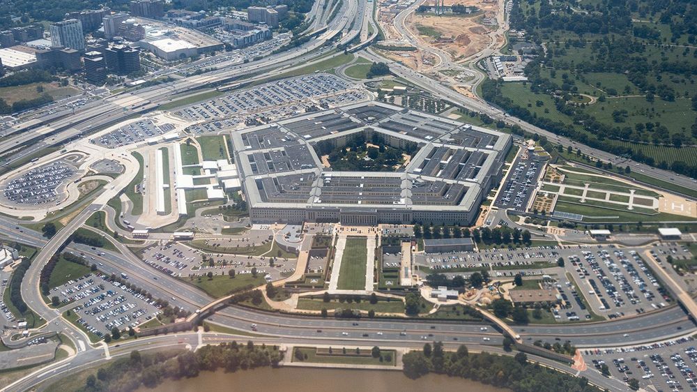 Aerial view of the Pentagon complex with surrounding roads, parking and greenery. g
