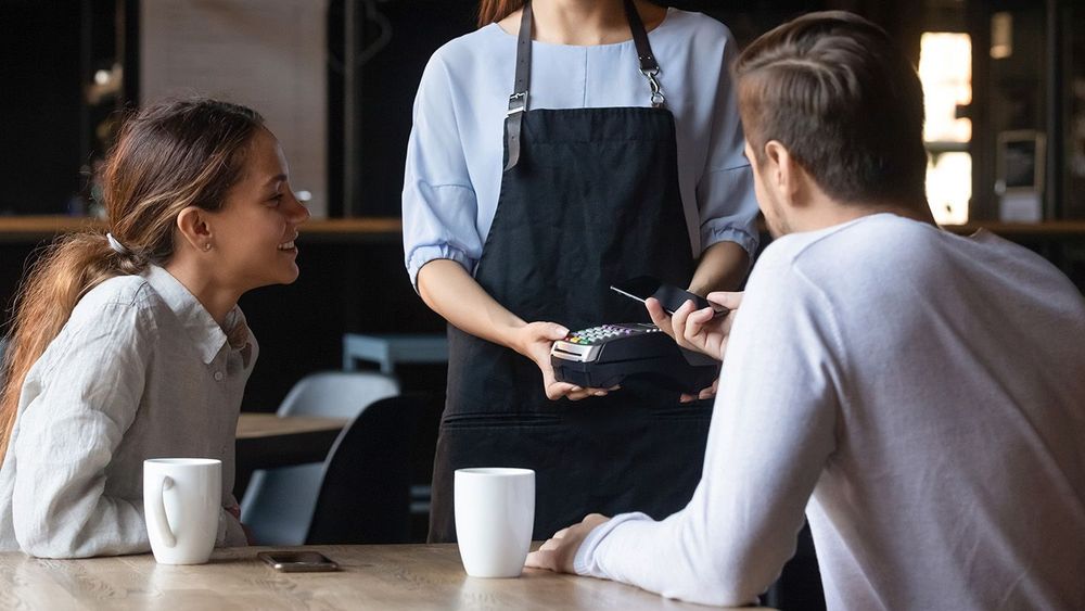 Client in cafe paying using mobile application NFC payment