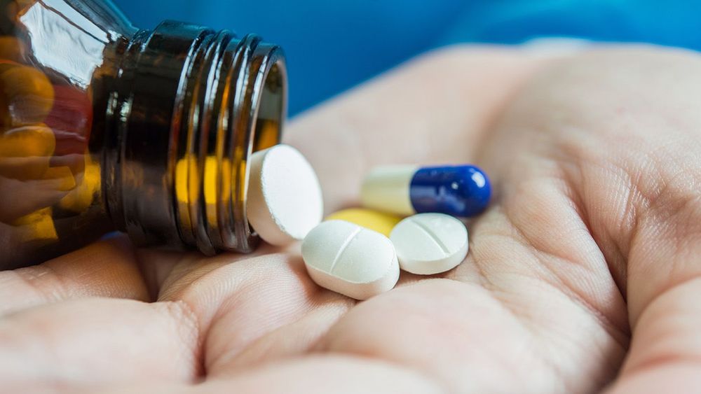 Woman's hand pours the medicine pills out of the bottle
