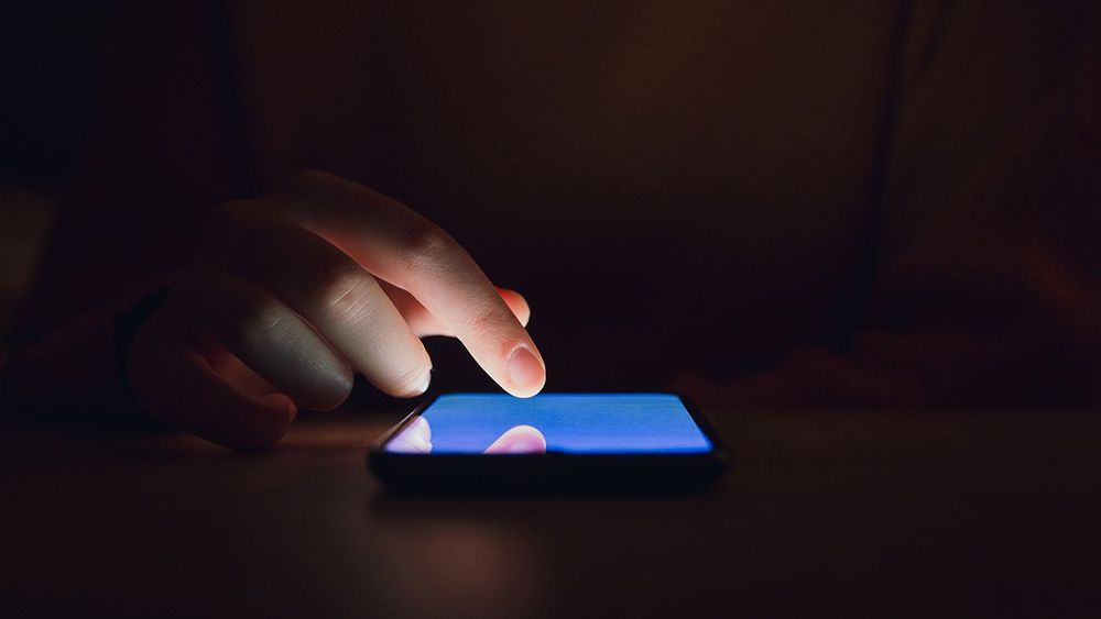 Stock photo of a woman using smartphone in the dark