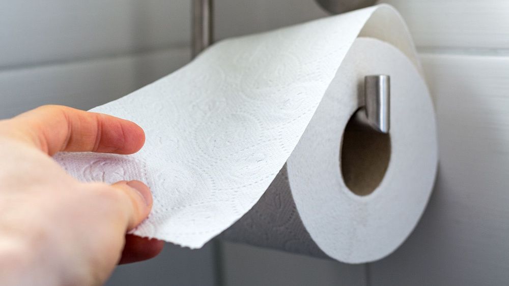 Man grabs toilet paper as a close up