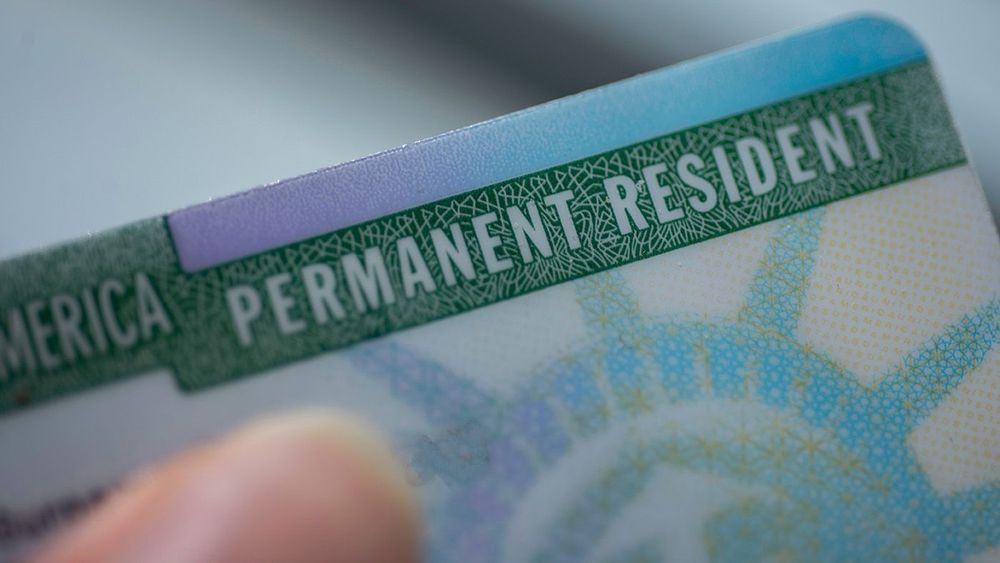 Close up view of Permanent resident card (Green) card of USA on blurred background.
