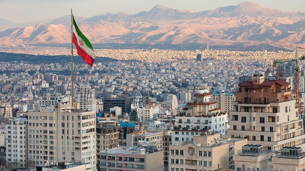 Aerial view of Tehran Skyline at Sunset with Large Iran Flag Wav