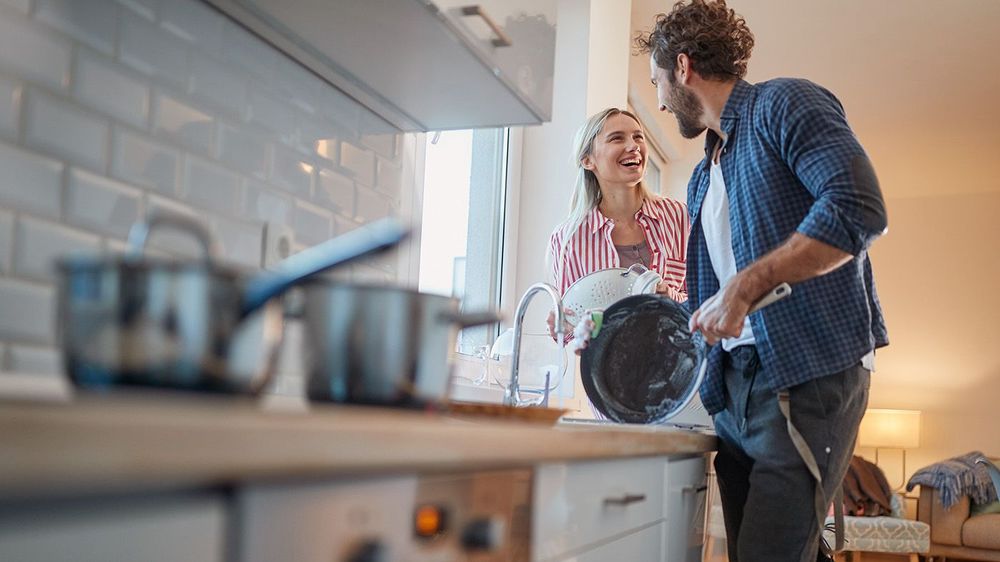 A young couple doing housework with satisfaction. Kitchen, house