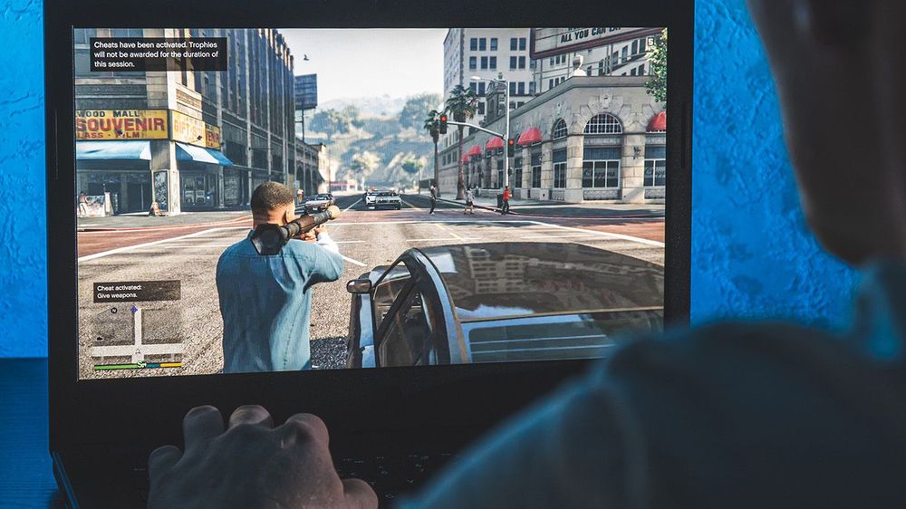 Person playing GTA V video game on computer