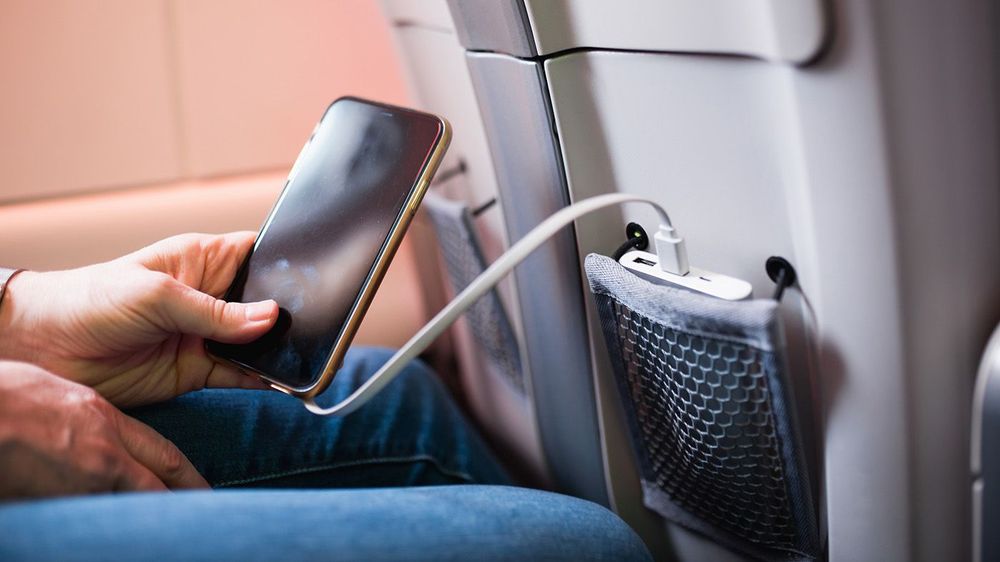 Paris, France - December 28, 2022: Convenient pocket in the airplane seat for storing your phone and portable charger