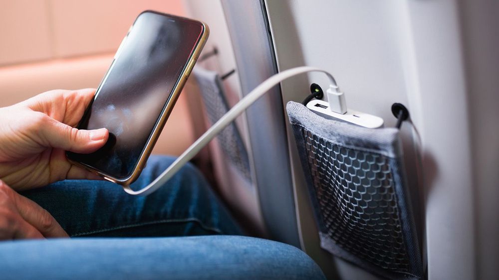 Paris, France - December 28, 2022: Convenient pocket in the airplane seat for storing your phone and portable charger