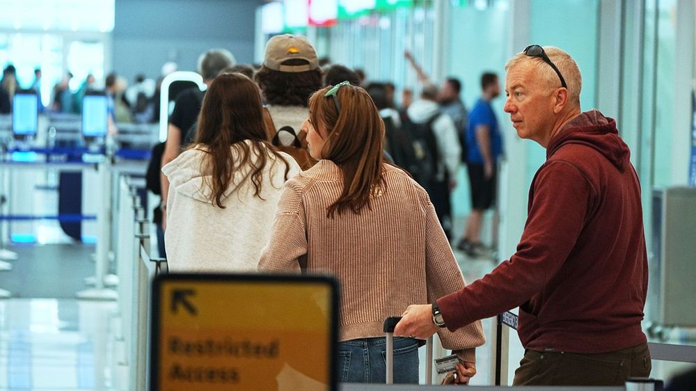 travellers queue up at west security checkpoint in denver airport