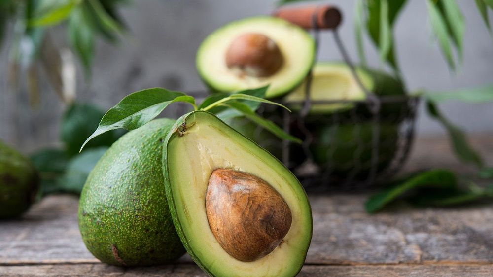 Fresh green avocado on wooden background. Selective focus. Horiz