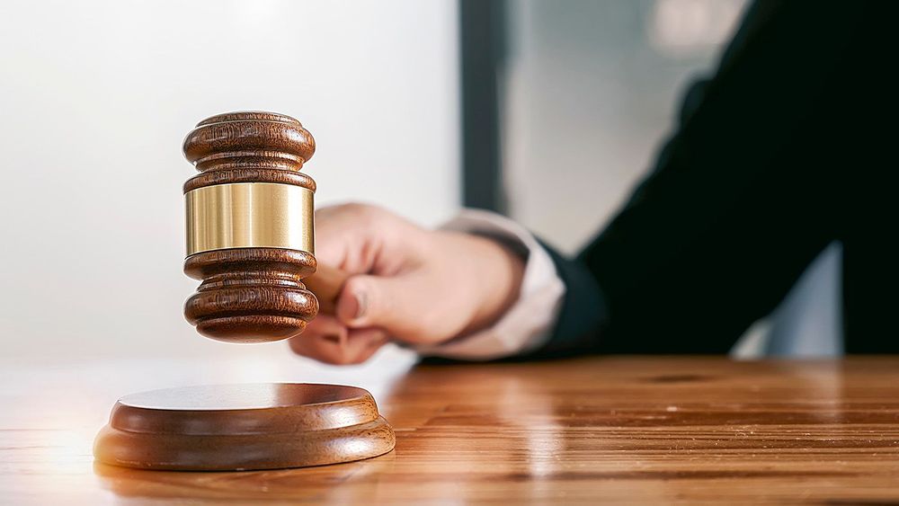 Woman judge hand holding gavel to bang on sounding block in the