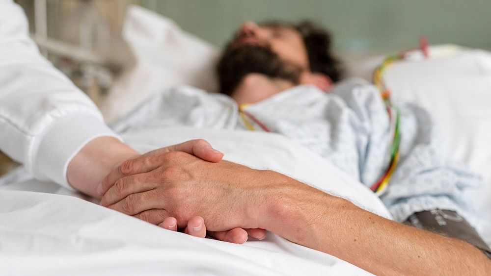 healthcare staff caring for a patient in hospital bed