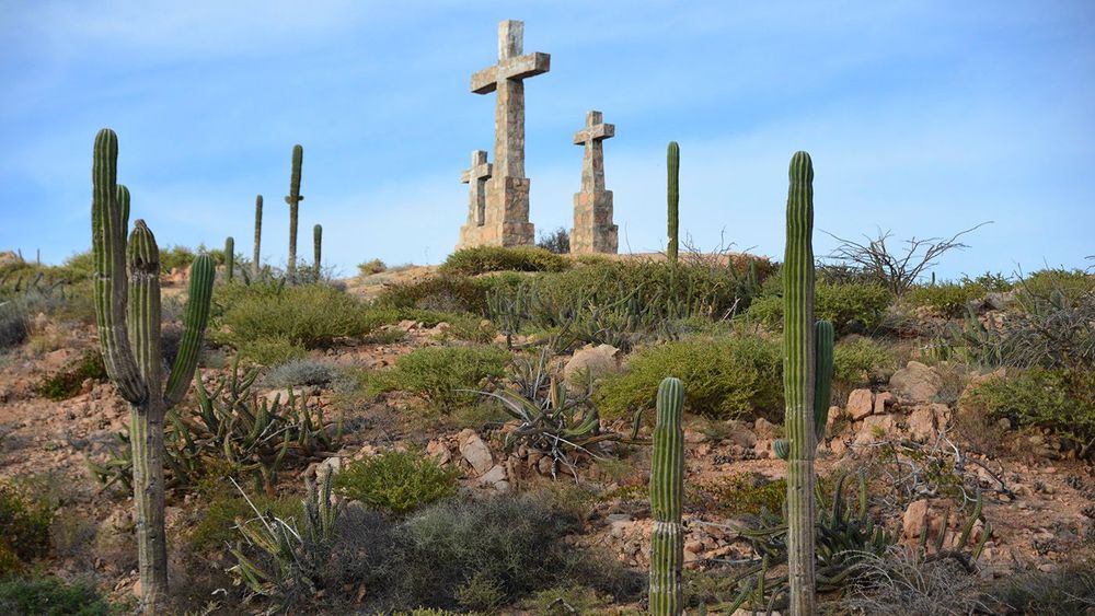 Three stone crosses and cacti on top of hillside overlooking Sea of Cortez on the Baja California Peninsula near La Paz Mexico