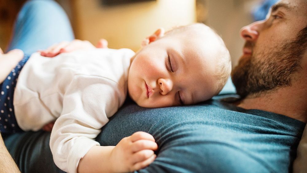 Father with a baby girl at home sleeping.