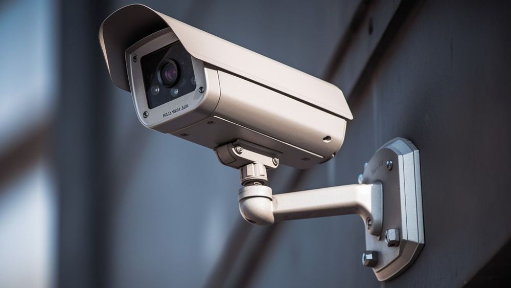 modern-cctv-camera-monitoring-surveillance-security-wall-with-car-park-background copy