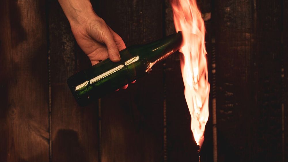 Molotov cocktail in the hands of a girl, martial law in Ukraine, a girl getting ready to defend her house, combustible mixture in bottles with a rag, war Ukraine