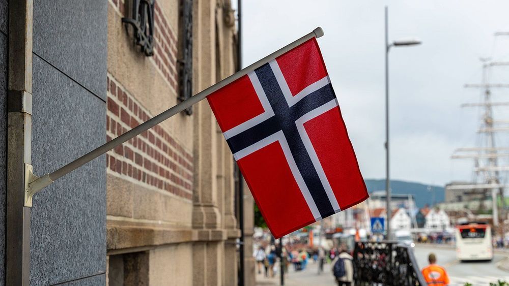 Bergen, Norway - 11 July 2023: A Norwegian flag hangs on a building. National flag of Norway *** Eine Norwegische Flagge