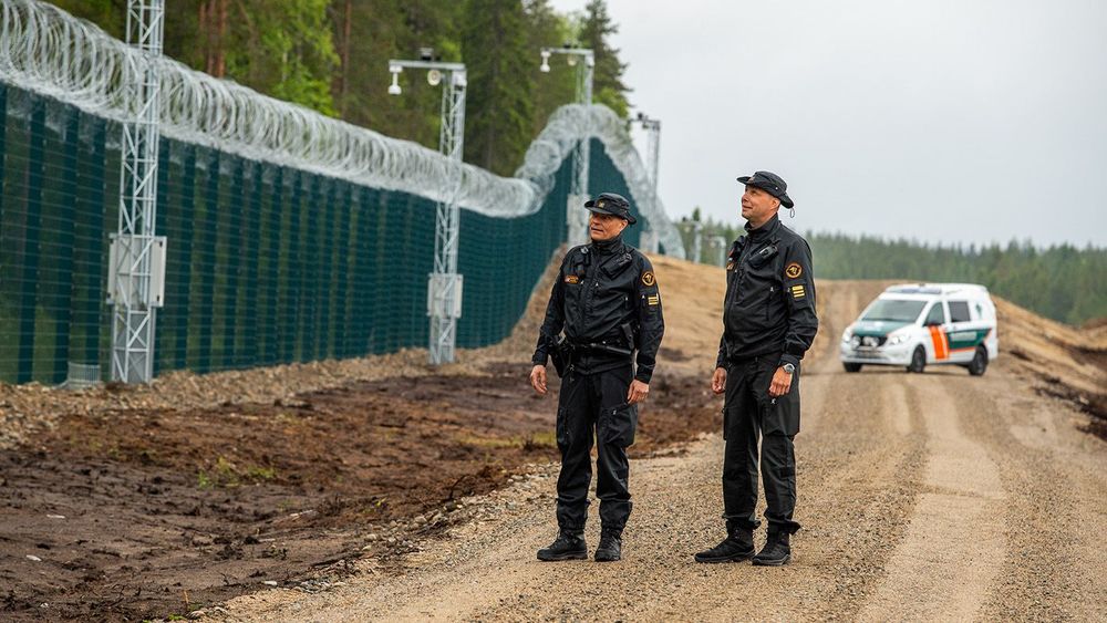 Finnish Border Guard at the barrier fence between Finland and Russia